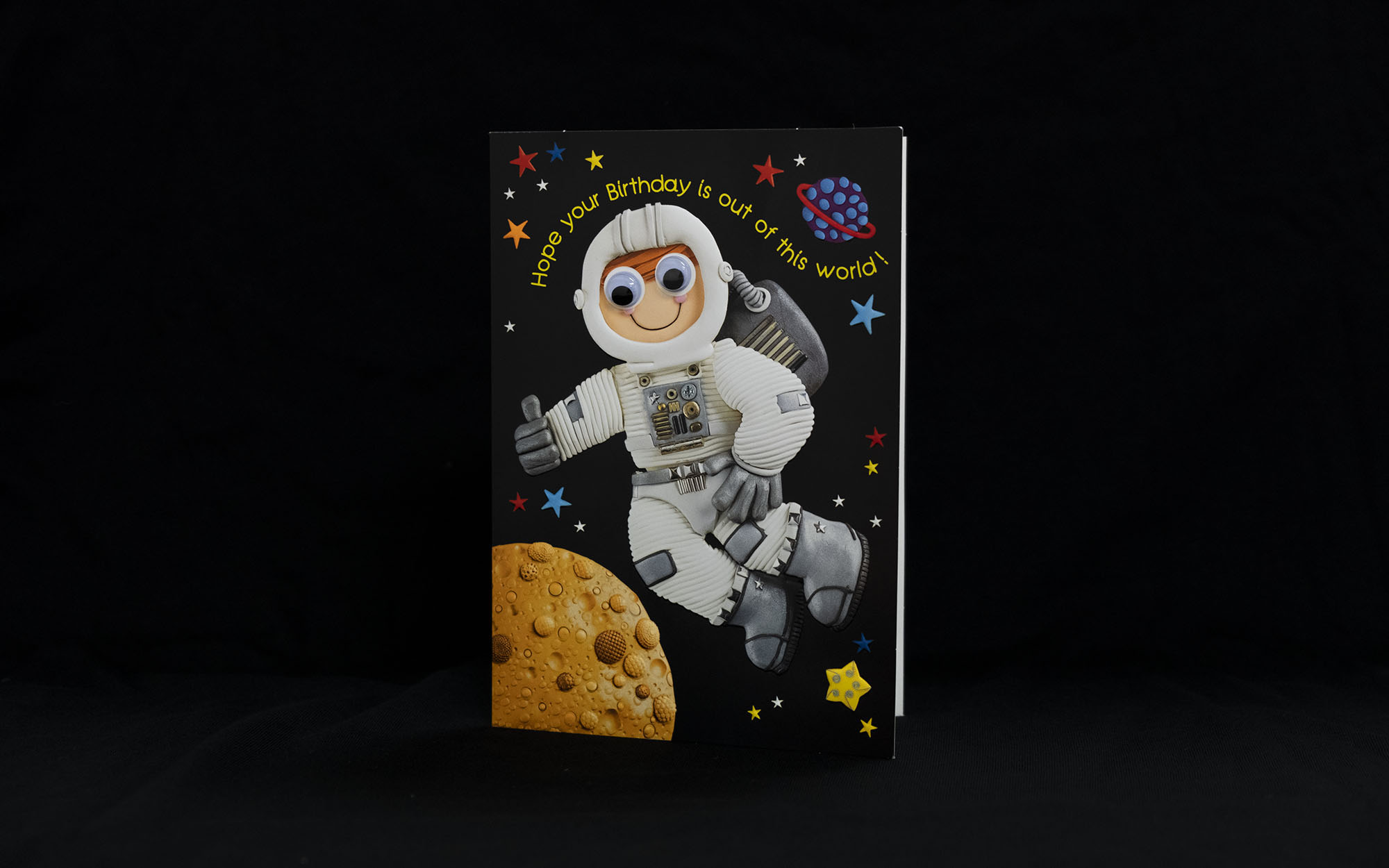 Birthday card with an astronaut on it and planets and stars. The card says "Hope your birthday is out of this world!"