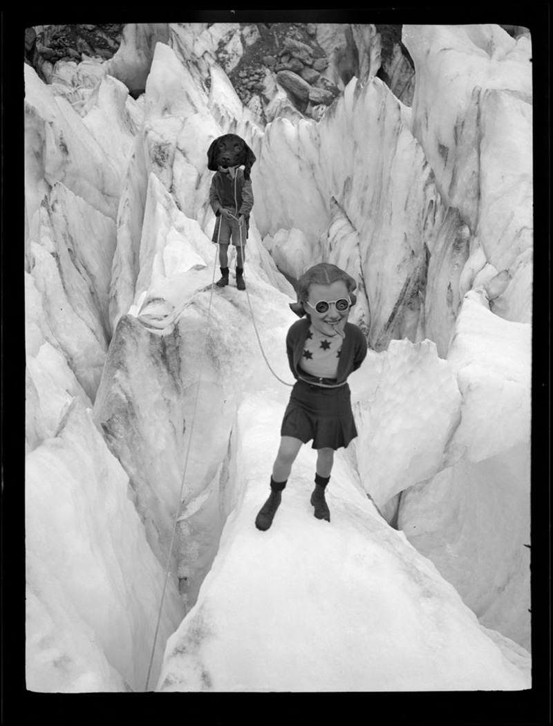 Photo montage of two people standing on an icy crevasse, one has the head of a dog with its tongue hanging out and the other has an enlarged head of a woman with the dog’s tongue hanging out of her mouth. They have swapped eyes