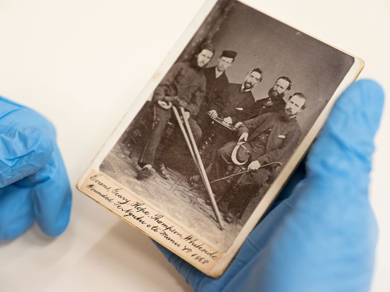 Someone is blue gloves holding an old photograph