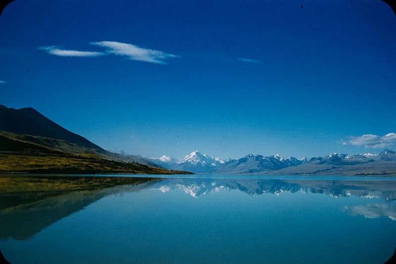 Photo of Lake Pukaki, with mirror-like water, and a view or Aoraki Mt Cook in the distance