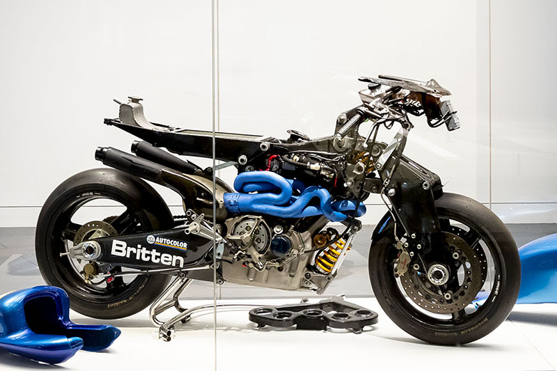 A motorbike on display in a large glass case