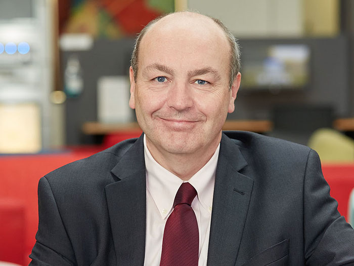 Geraint Martin sits smiling on a sofa