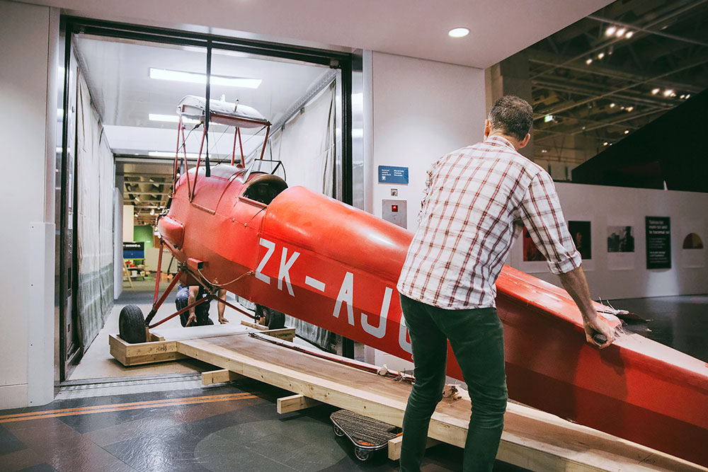 The Tiger Moth is wheeled into an elevtor