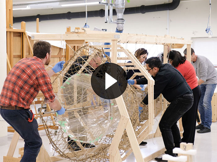 A number of people insert a special mount inside a big eel net