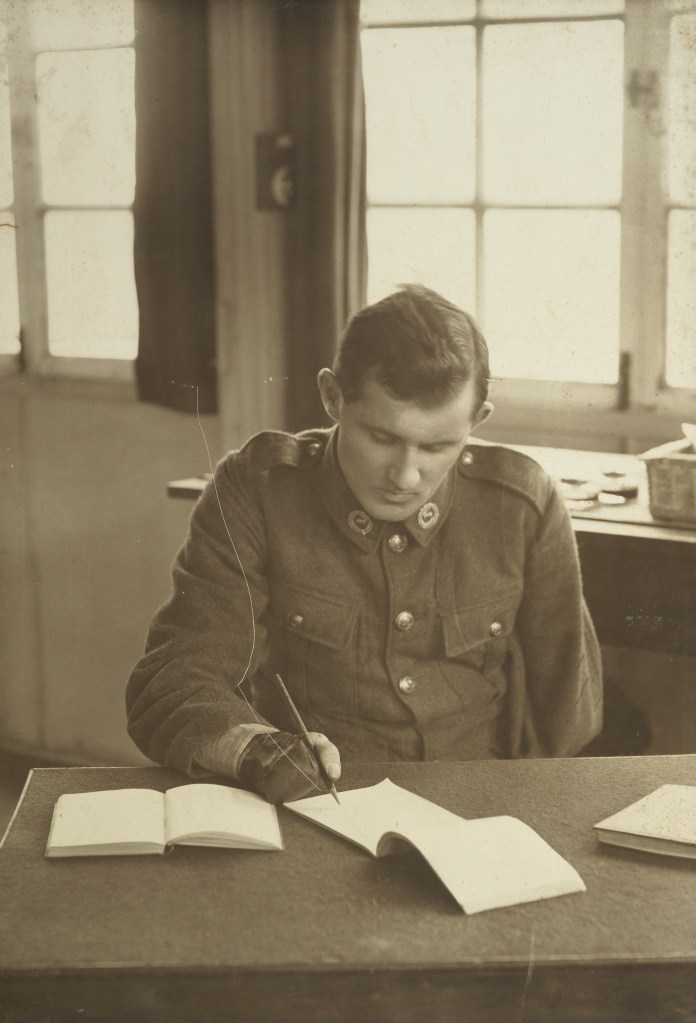 A soldier with one arm sits at a desk