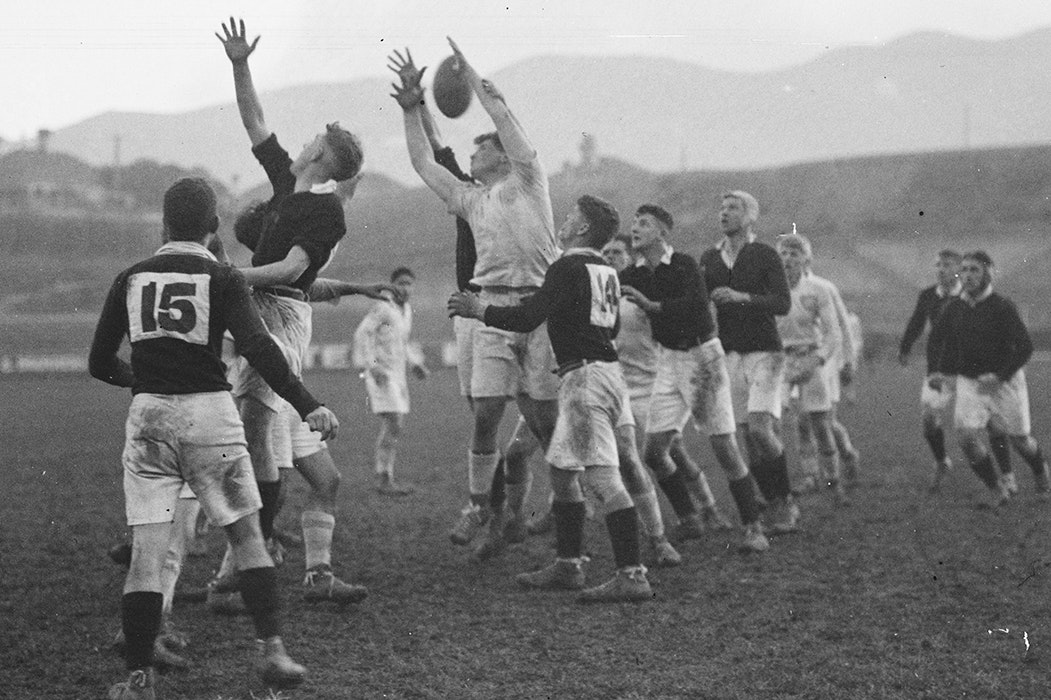 A black and white photo of two teams playing rugby