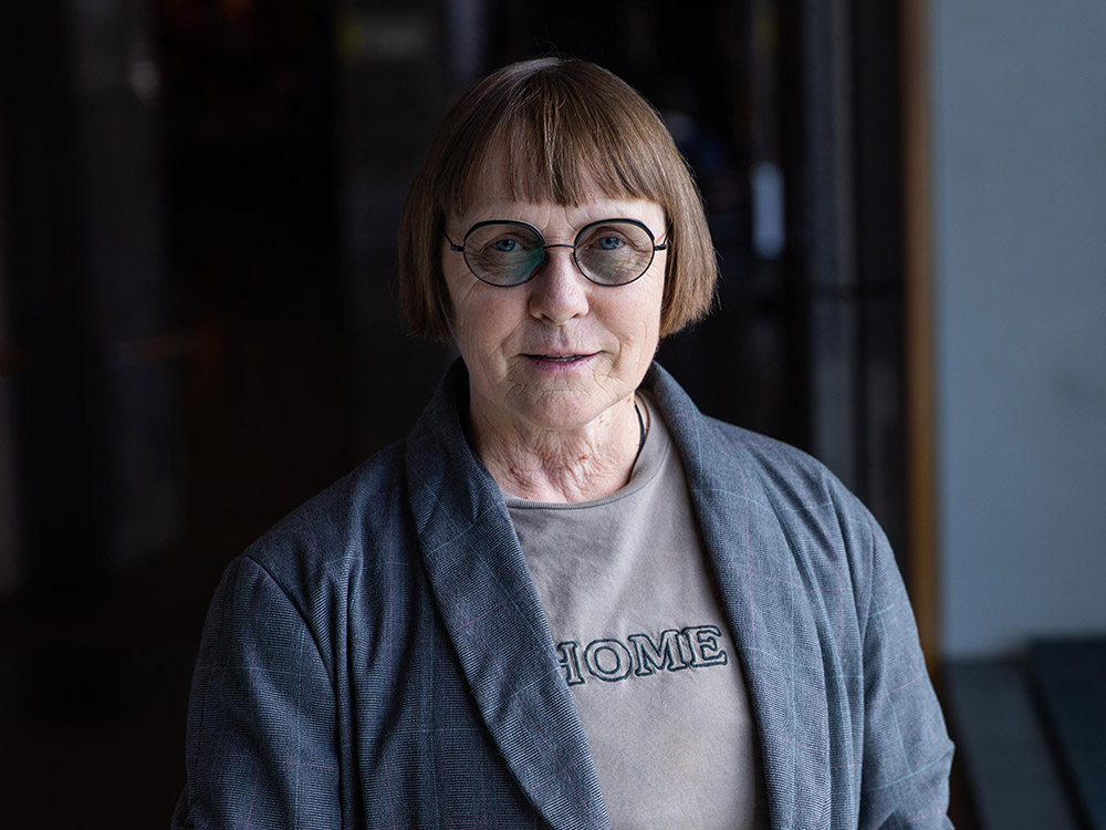 A photo of a woman wearing glasses in a dark hallway