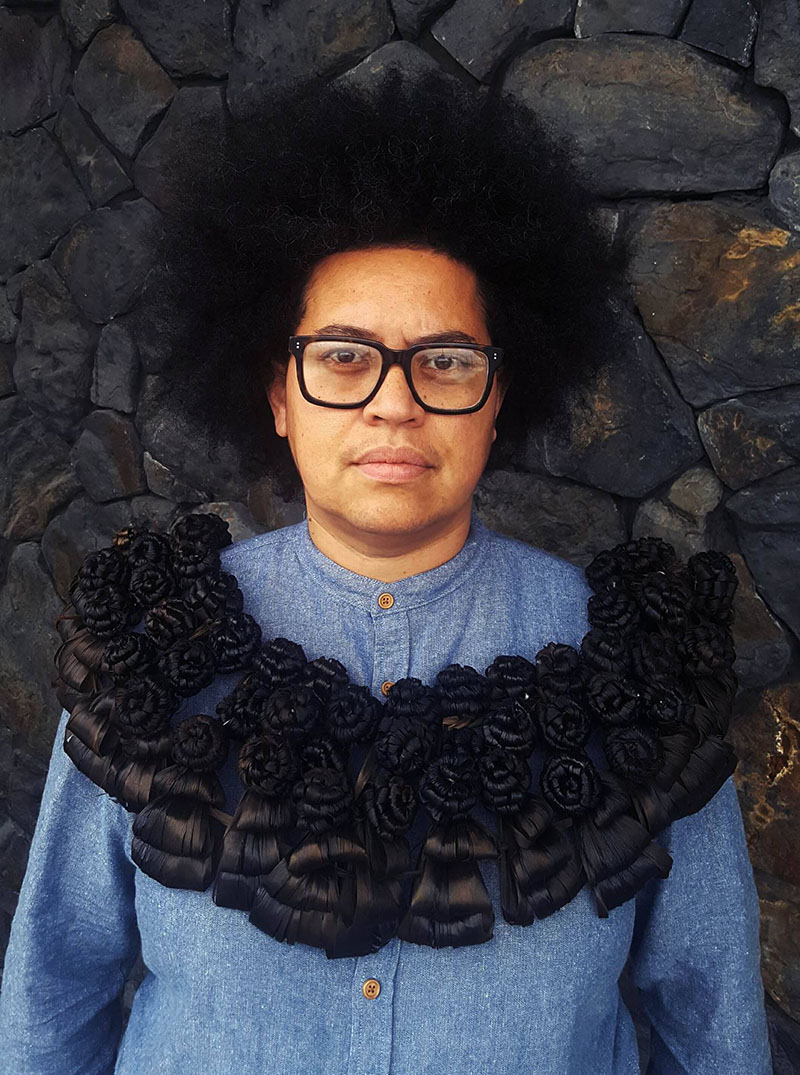 Portrait of a woman, wearing a black salusalu – necklace – made to look like a wreath of flowers