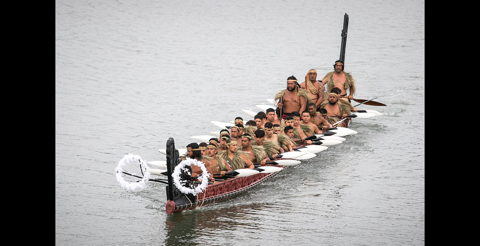 Photo of a group of men in a waka in a body of water