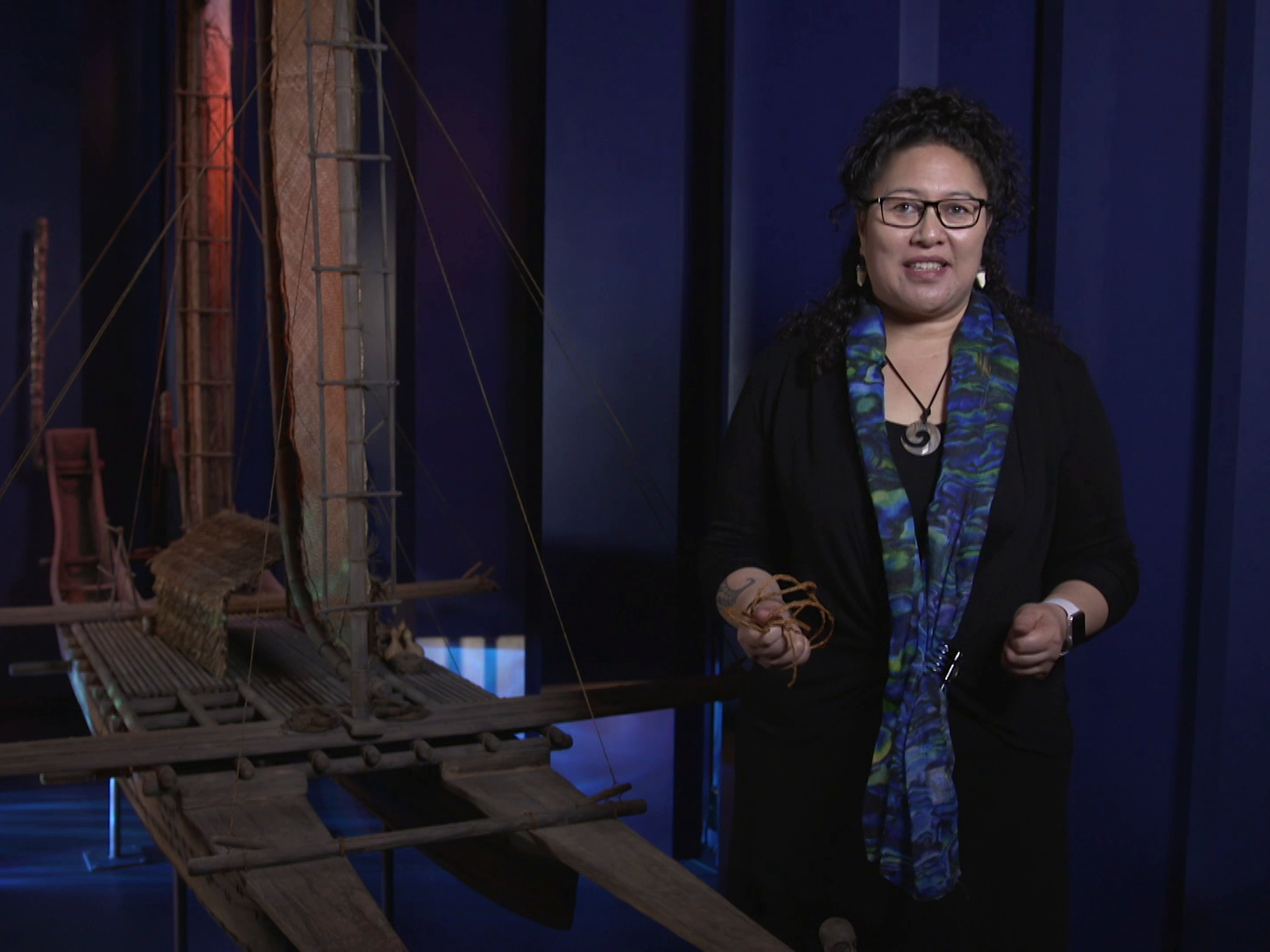 A woman standing inside in front of a canoe