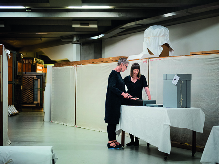 Two women standing beside a table